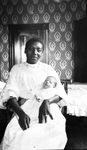 African American woman holding infant by Charles M. Davis