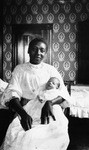 African American woman holding infant by Charles M. Davis