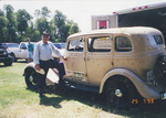 Dr. Emerson Emory posing next to car