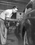 A man painting a car in the Vandergriff automobile body shop