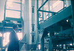 Man observing tall metal tank with windows, Carling Brewery