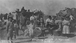 Portrait photograph taken of a group of Mexican soldiers, men, women, and children during Mexican Revolution by W. H. Horne Company