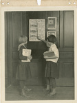 Two girls reading "That Fallen Wire" poster