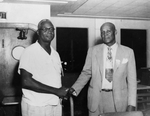 A photograph of two unidentified African American men shaking hands.