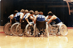 University of Texas at Arlington (U. T. A.) Freewheelers team on basketball court in huddle