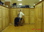 Jim Hayes using a wheelchair beside lockers, location not identified