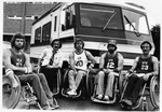 Five members of the U. T. A. Movin' Mavs basketball team in front of a van