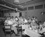 Groups of men eating food at long tables. Most of the men are wearing leis by Squire Haskins Photography Inc.