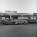 Shopping center storefronts. Weaver Carpets store and a Sherwin-Williams Paint company store are visible. Two vans with the Weaver Carpets logo are parked in front of the store by Squire Haskins Photography Inc.