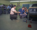 Color photo of several men working on cars and machinery by Squire Haskins Photography Inc.