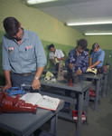 Students at metal tables working on small machine parts by Squire Haskins Photography Inc.