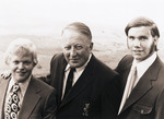 Two young men flank an older man in a pose. All are wearing sport jackets and ties by Squire Haskins Photography Inc.