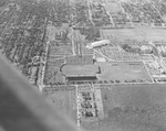 Football stadium at Southern Methodist University, Dallas, Texas. The stands are filled while the game is being played. The Goodyear Blimp is flying over the stadium by Squire Haskins Photography Inc.