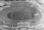 Aerial view of the Cotton Bowl, Fair Park, Dallas, Texas. The stadium is full of people watching a game by Squire Haskins Photography Inc.