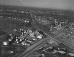 Oil derricks in a small town, location unknown by Squire Haskins Photography Inc.