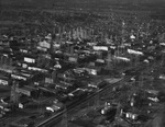 Oil derricks in a small town, location unknown by Squire Haskins Photography Inc.