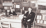 Two older men in suits seated at an executive's table by Squire Haskins Photography Inc.