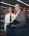 Two men standing in front of a grocery store aisle by Squire Haskins Photography Inc.