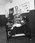 Man standing behind a model of a rotary engine by Squire Haskins Photography Inc.