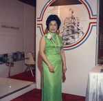 Woman standing in and exhibit of the Cable & Wireless Company by Squire Haskins Photography Inc.