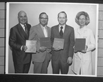 Group of three men, unknown, and Doris J. Wilson, RN, holding copies of the Dallas Area Diet Manual, 1972 by Squire Haskins Photography Inc.