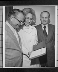 Doris J. Wilson, RN, showing the Dallas area diet manual 1972 booklet to two men in suits by Squire Haskins Photography Inc.