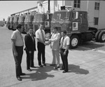 Men posing in front of a warehouse and Briggs semi truck cabs by Squire Haskins Photography Inc.