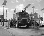 Man putting fuel into a Briggs semi truck cab by Squire Haskins Photography Inc.