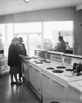 Man and woman view kitchen appliances by Squire Haskins Photography Inc.