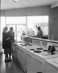 Man and woman view kitchen appliances by Squire Haskins Photography Inc.