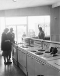 Man and woman view kitchen appliances in a showroom by Squire Haskins Photography Inc.