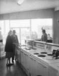 Man and woman view kitchen appliances in a showroom by Squire Haskins Photography Inc.