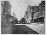 Dallas, Texas downtown street scene with street car on tracks and horse-drawn buggies along side of street by Squire Haskins Photography Inc.