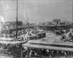 Lines of streetcars with crowds of people waiting to board the train at the Dallas Union Depot of the Houston & Texas Central Railroad by Squire Haskins Photography Inc.