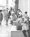 Downtown Dallas, Texas crowds on sidewalk, man in foreground reading a newspaper by Squire Haskins Photography Inc.