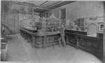 Bank interior with cashiers in cages and customer in lobby