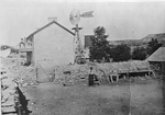 Two-story farm house with rock fence