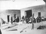 Mexican soldiers in groups outside one-story building