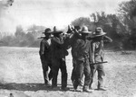 Mexican soldiers wearing sombrero hats, carrying wounded soldiers