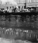 Fire fighters using Fire Department pump wagon beside river or canal by United Photo Service