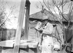 Tex Rickard drinking from the well he dug as a youth outside of Rickard's family home in Henrietta, Texas
