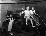 Fort Worth Frontier Centennial show girls on the outside of an old stage coach
