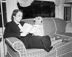 Kate McAlpin Crady reads to Lam, her pet dog, 1938