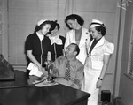 Paul Whiteman surrounded by young women seeking position of vocalist with his orchestra