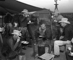 Cowboys and little girl eating at chuck wagon on Spur Ranch