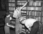 Librarian and workmen moving books from Carnegie Public Library to temporary location