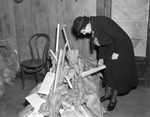 Mrs. S.M. Conger, working at the Pioneer Palace, examines a Goodfellow's Christmas bag she has filled for a family with children, 12/21/1937