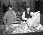 Avery Payne, mail clerk for Fort Worth Municipal Airport, assists Chief Clerk W. Francis with sorting and preparing airmail