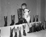 Reggie Rogers, 4, of Wichita Falls, inspects size 17 boot made by Nocona Boot Company for Al Tominiti, giant in a circus