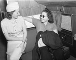 From left, Pat Mullally, stewardess on American Airlines, with Ruth Singer of Los Angeles who is flying to Detroit to receive surgery to save her eyesight